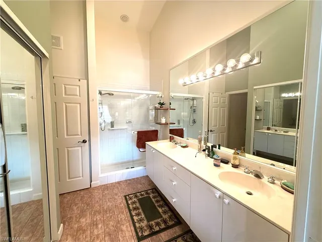 a bathroom with a double vanity sink a mirror and a shower