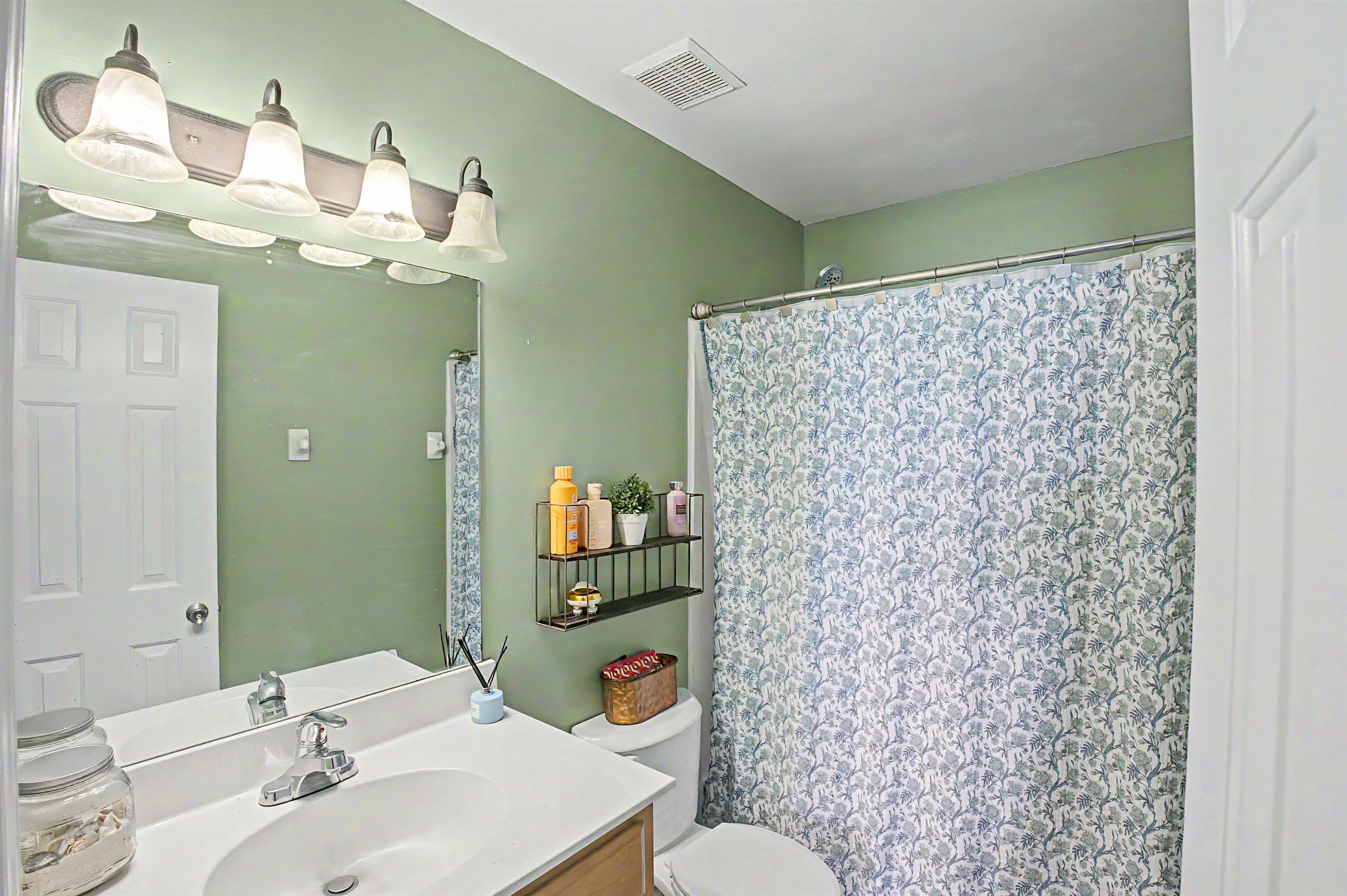134 Rembert Drive Atoka, TN 38004 - Photo 31 of 38 Bathroom featuring a single vanity with a white countertop, chrome faucet, and a large wall-mounted mirror