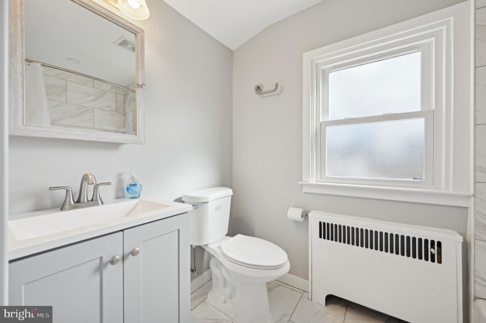 1230 MacDade Boulevard Woodlyn, PA 19094 - Photo 13 of 16 a bathroom with a toilet a sink a mirror and a window