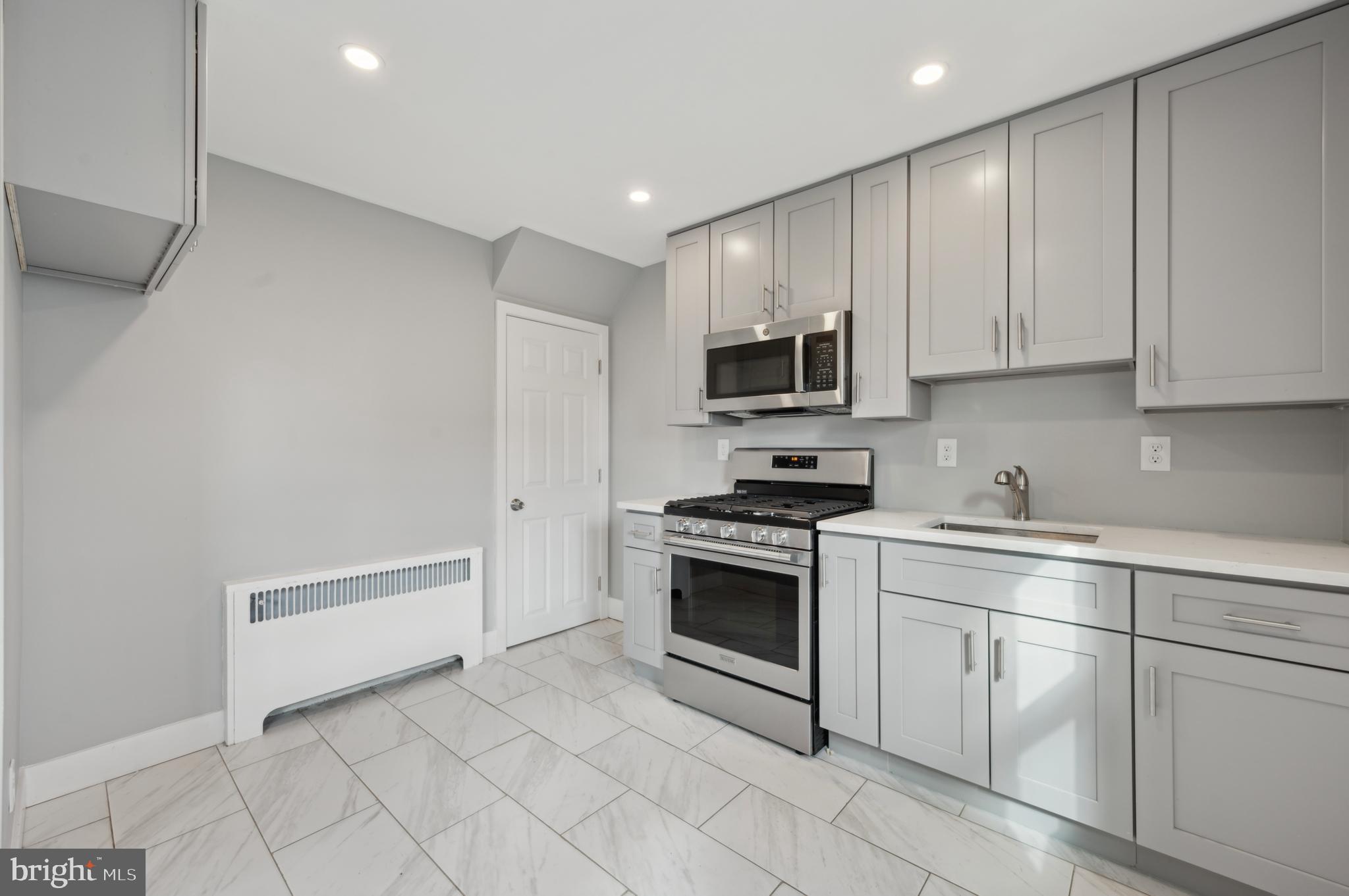 1230 MacDade Boulevard Woodlyn, PA 19094 - Photo 7 of 16 a kitchen with white cabinets and appliances