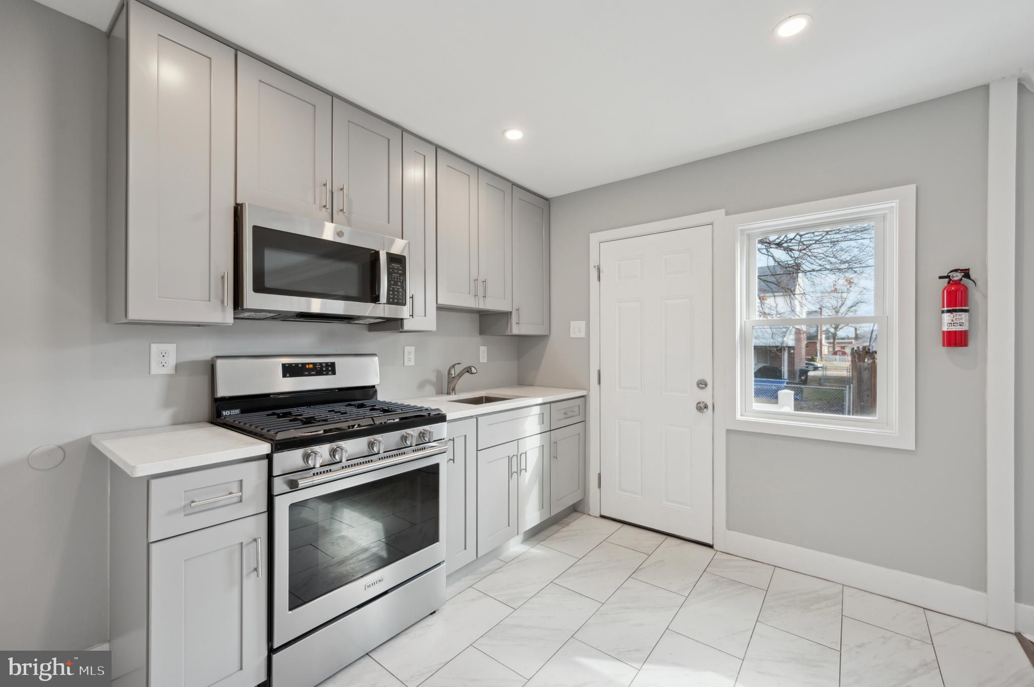 1230 MacDade Boulevard Woodlyn, PA 19094 - Photo 9 of 16 a kitchen with granite countertop a stove top oven microwave and cabinets