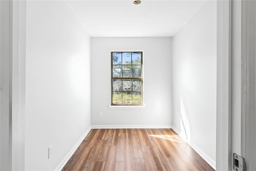 17380 Northwest Green Acres Road Bristol, FL 32321 - Photo 15 of 35 a view of an empty room with wooden floor and a window