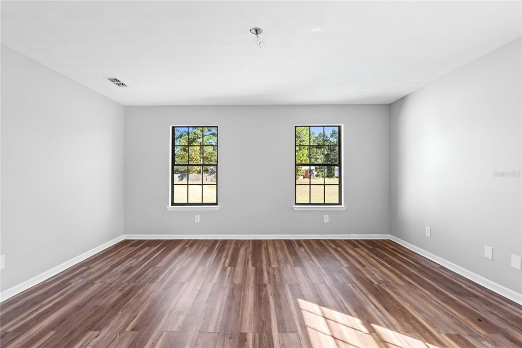 17380 Northwest Green Acres Road Bristol, FL 32321 - Photo 20 of 35 a view of empty room with wooden floor and fan