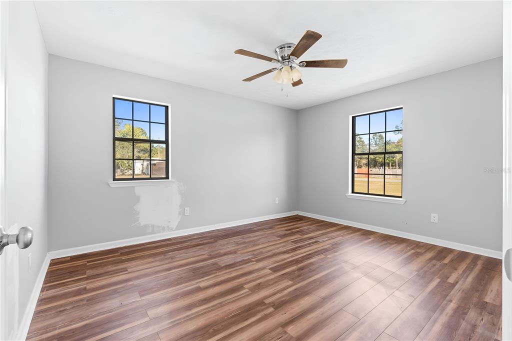17380 Northwest Green Acres Road Bristol, FL 32321 - Photo 29 of 35 a view of empty room with wooden floor and fan