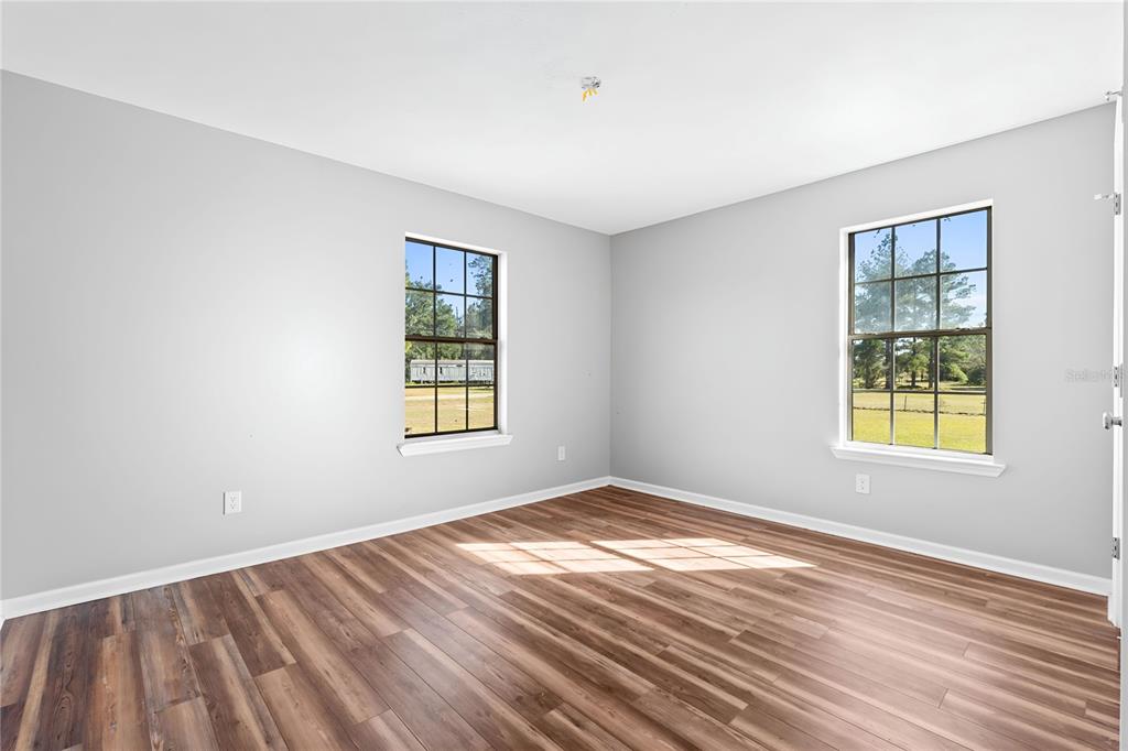 17380 Northwest Green Acres Road Bristol, FL 32321 - Photo 34 of 35 a view of an empty room with wooden floor and a window