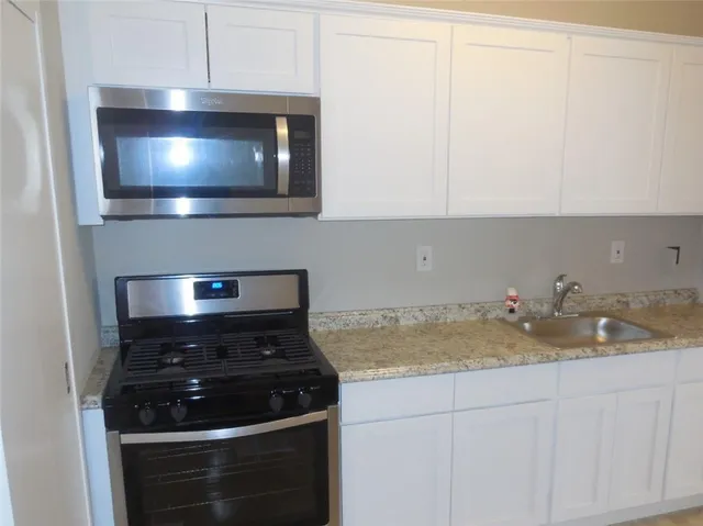 a kitchen with a stove and white cabinets
