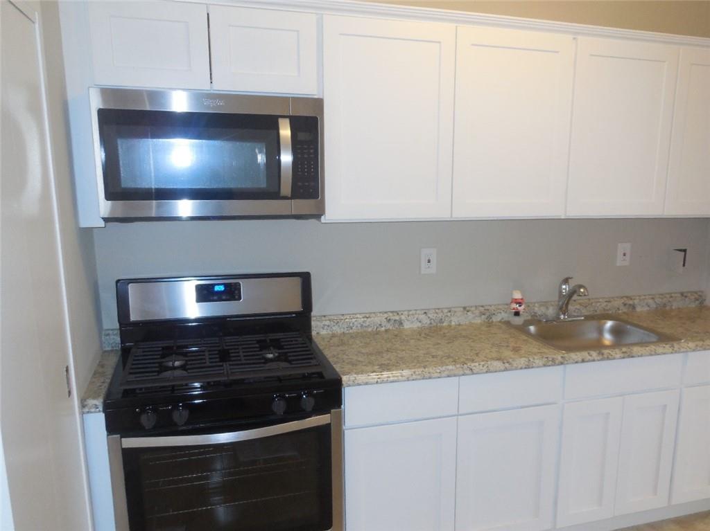 3 Fordham Hill Ovl, Unit 4A Bronx, NY 10468 - Photo 2 of 7 a kitchen with a stove and white cabinets
