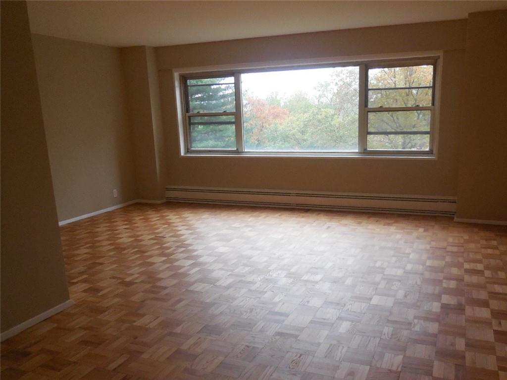 3 Fordham Hill Ovl, Unit 4A Bronx, NY 10468 - Photo 5 of 7 an empty room with wooden floor and windows