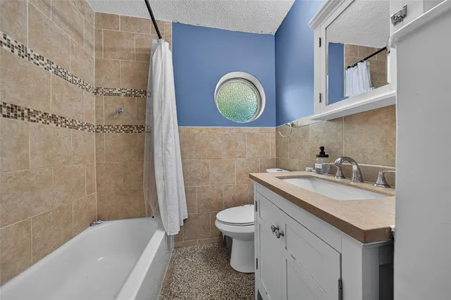 a bathroom with a granite countertop toilet sink and mirror