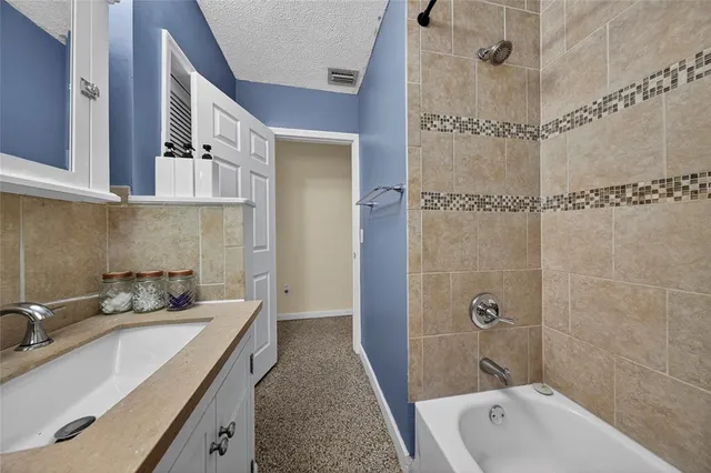 a bathroom with a granite countertop sink a mirror and shower