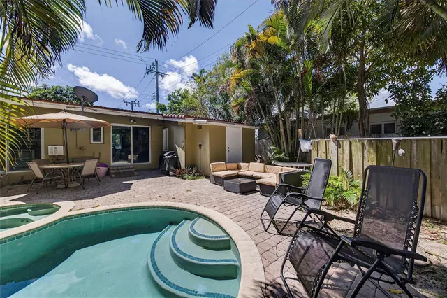 a view of backyard with swimming pool and furniture