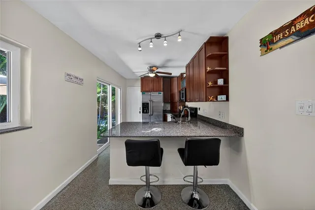 a kitchen with stainless steel appliances kitchen island granite countertop a table and chairs in it