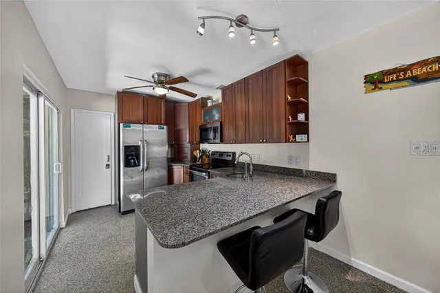 a kitchen with stainless steel appliances granite countertop a sink refrigerator and cabinets