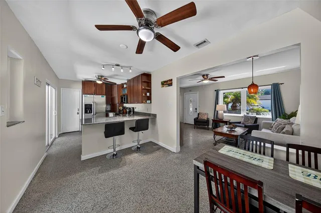 a living room with furniture kitchen view and a window
