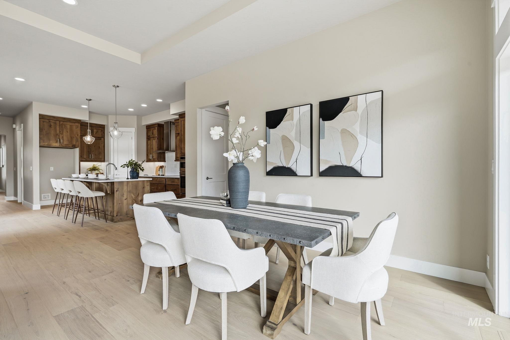 470 South Radiator Way Boise, ID 83716 - Photo 17 of 50 Open-concept dining area featuring wood-finish flooring, a contemporary dining table, recessed lighting, and a visible kitchen with a large island and pendant lighting
