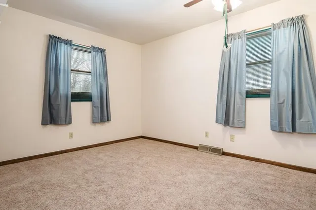 an empty room with windows and closet