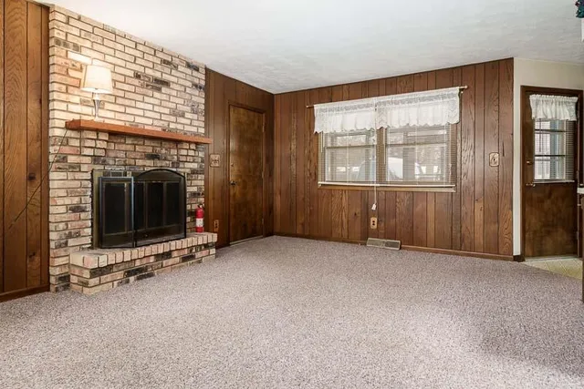 an empty room with windows and fireplace