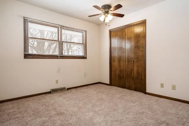 an empty room with windows and fan