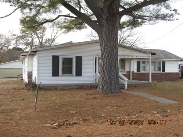 a house that has a tree in front of the house