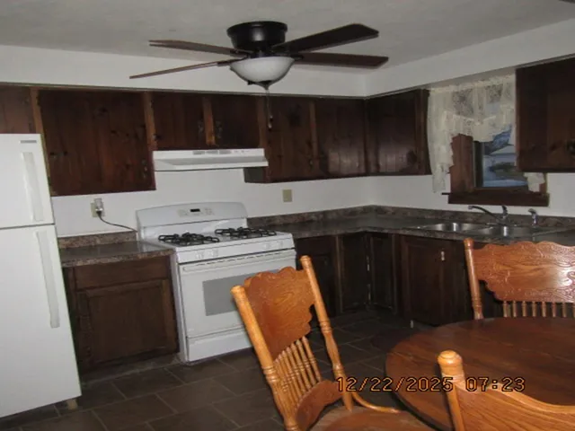a kitchen with stainless steel appliances granite countertop a stove a sink and a refrigerator