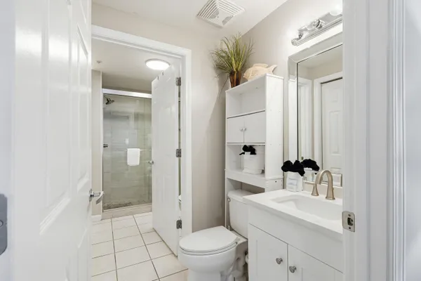 a bathroom with a sink a toilet and shower
