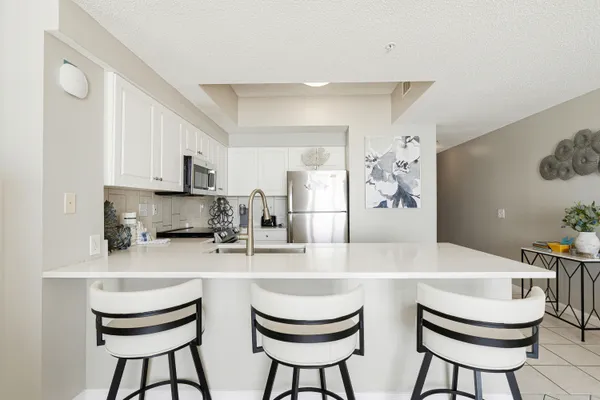 a kitchen with stainless steel appliances a dining table chairs and a refrigerator
