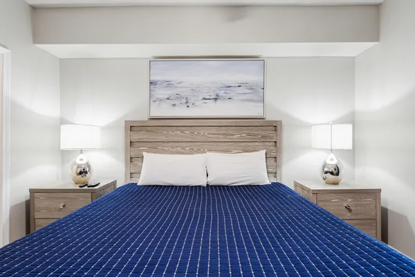 a bedroom with a bed and painting on the wall