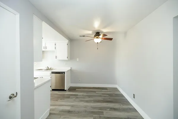 a view of a kitchen with a sink cabinets and wooden floor