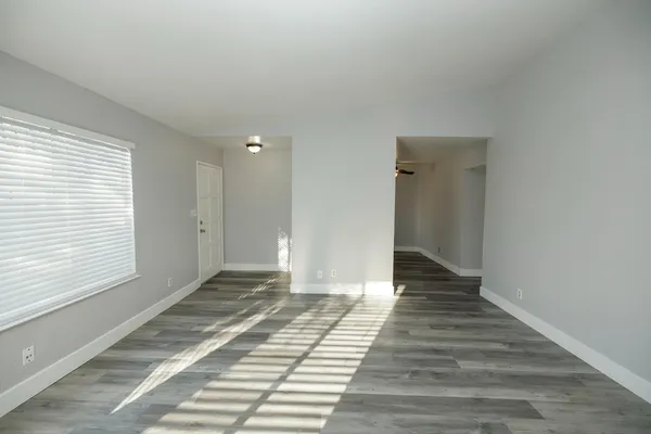 a view of a bedroom with wooden floor and a bathroom
