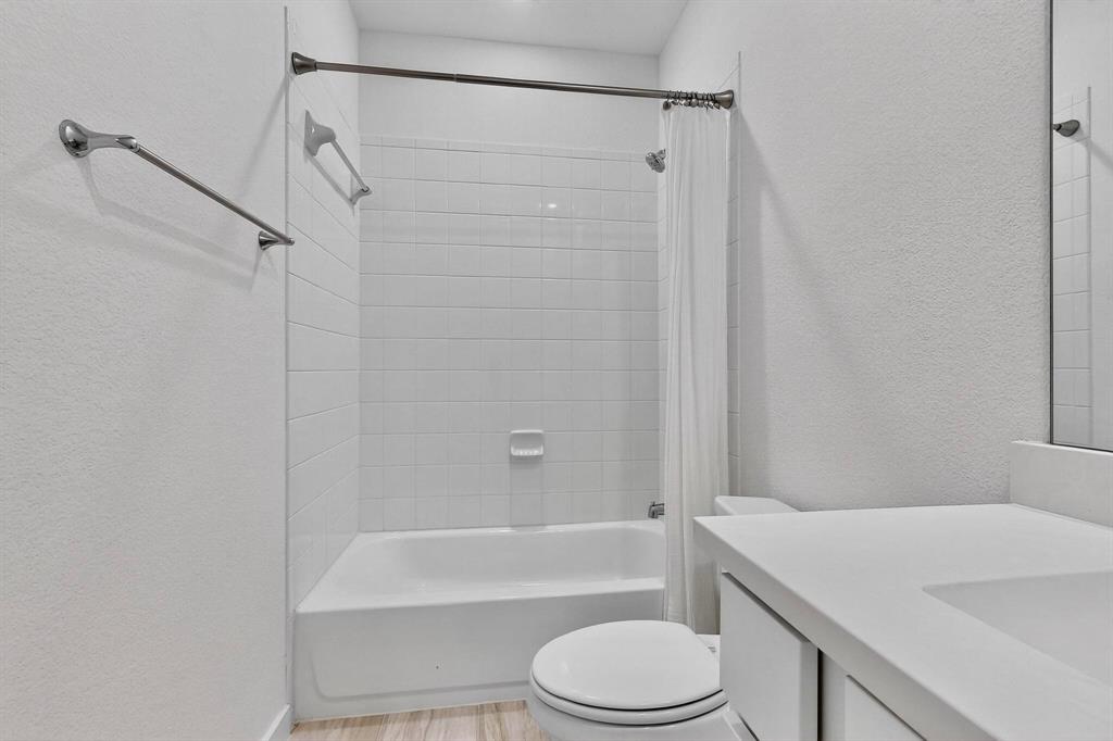 2017 Fall Crk Cove Mesquite, TX 75181 - Photo 22 of 40 Full bathroom featuring a textured wall, shower / bath combo with shower curtain, vanity, and light wood-type flooring