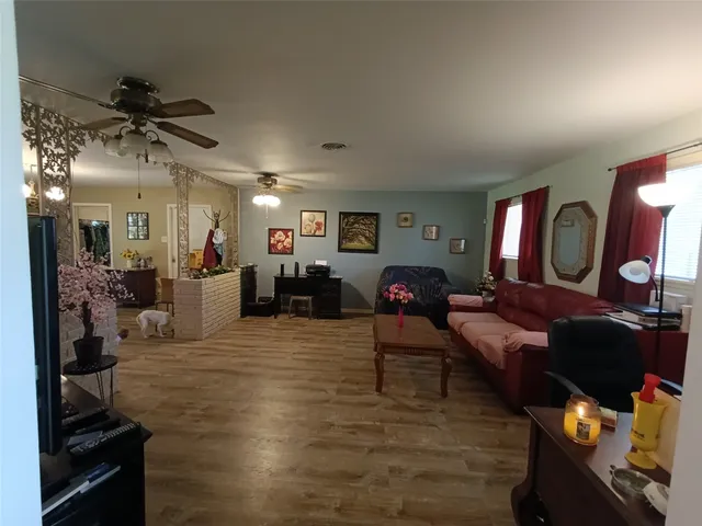 a living room with furniture and a wooden floor