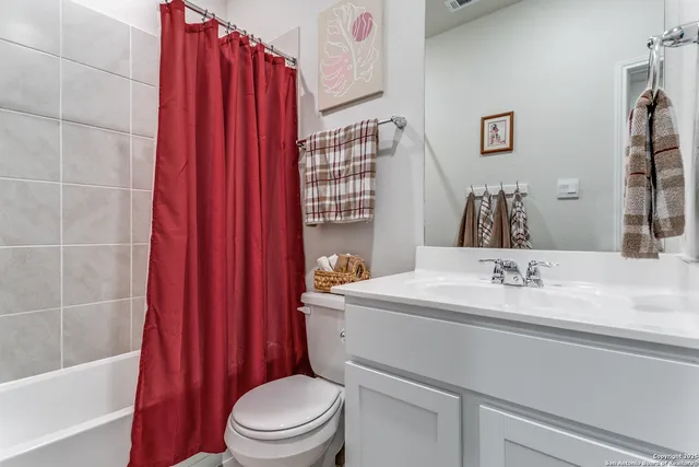 a bathroom with a sink a toilet and shower curtain
