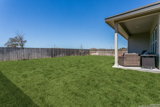 a view of a backyard with table and chairs and wooden fence