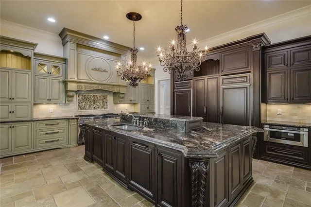 a kitchen with stainless steel appliances granite countertop a sink and a refrigerator