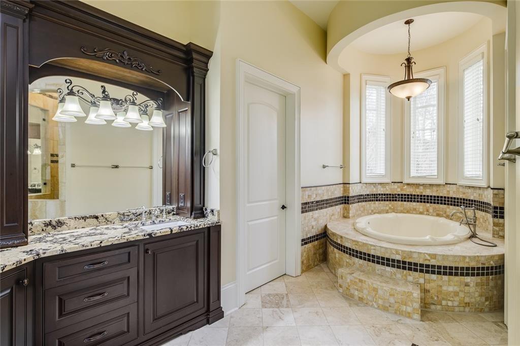 35 Mt Paran Road Northwest Sandy Springs, GA 30327 - Photo 28 of 61 a spacious bathroom with a granite countertop tub and a mirror