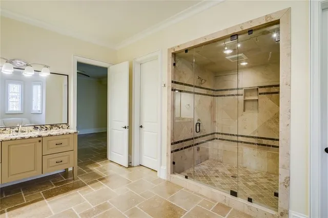a view of a brick house with a large tree and wooden fence