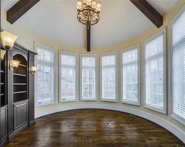 a view of a big room with wooden floor and windows