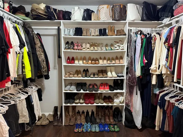 a view of walk in closet with clothes and shoes