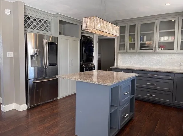 a kitchen with kitchen island a counter top space cabinets and stainless steel appliances