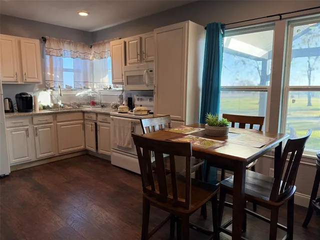 a kitchen with a table chairs sink and cabinets
