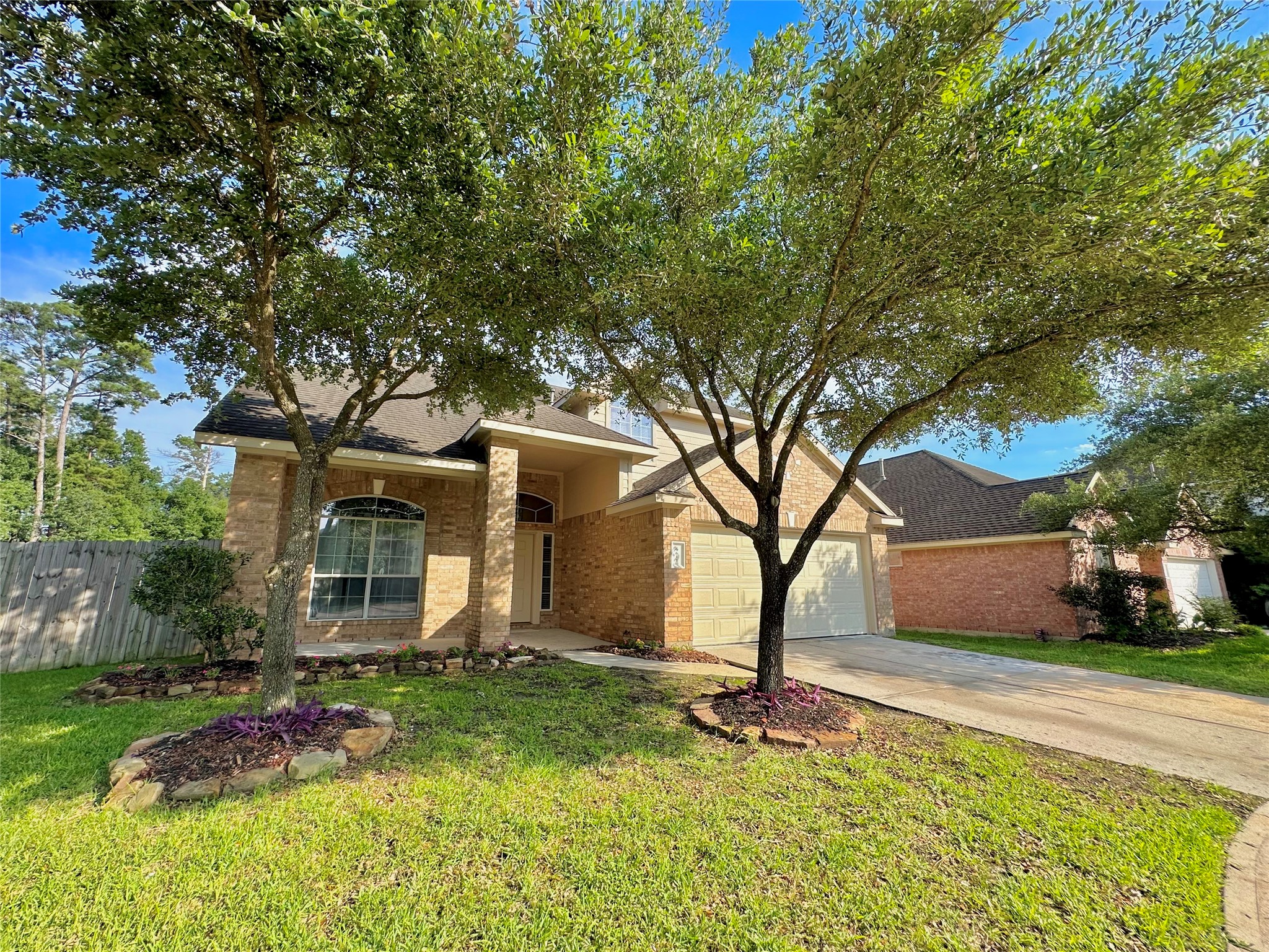 Charming brick home with a welcoming front porch, shaded by mature trees. Features a well-maintained lawn and a two-car garage, offering great curb appeal in a serene neighborhood setting.