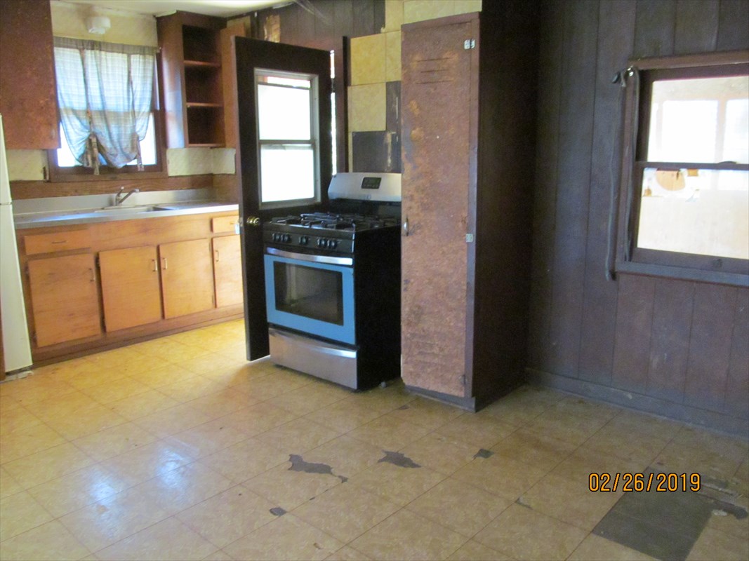 5681 Kaapuni Road Kapaa, HI 96746 - Photo 2 of 8 a kitchen with stainless steel appliances granite countertop a stove a sink and a refrigerator with wooden floors