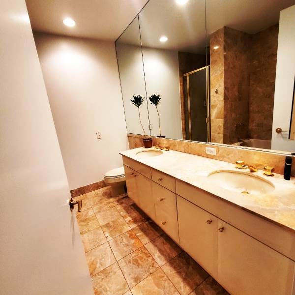 845 United Nations Plaza, Unit 5D Manhattan, NY 10017 - Photo 12 of 28 a spacious bathroom with a double vanity sink a mirror and a shower