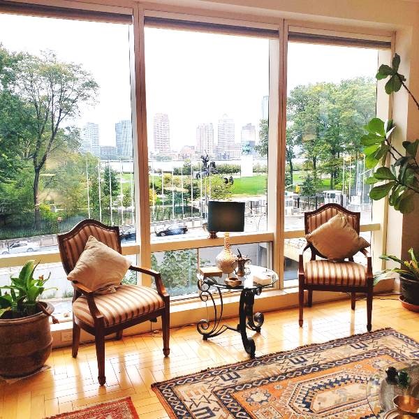 845 United Nations Plaza, Unit 5D Manhattan, NY 10017 - Photo 6 of 28 a living room with furniture and a floor to ceiling window