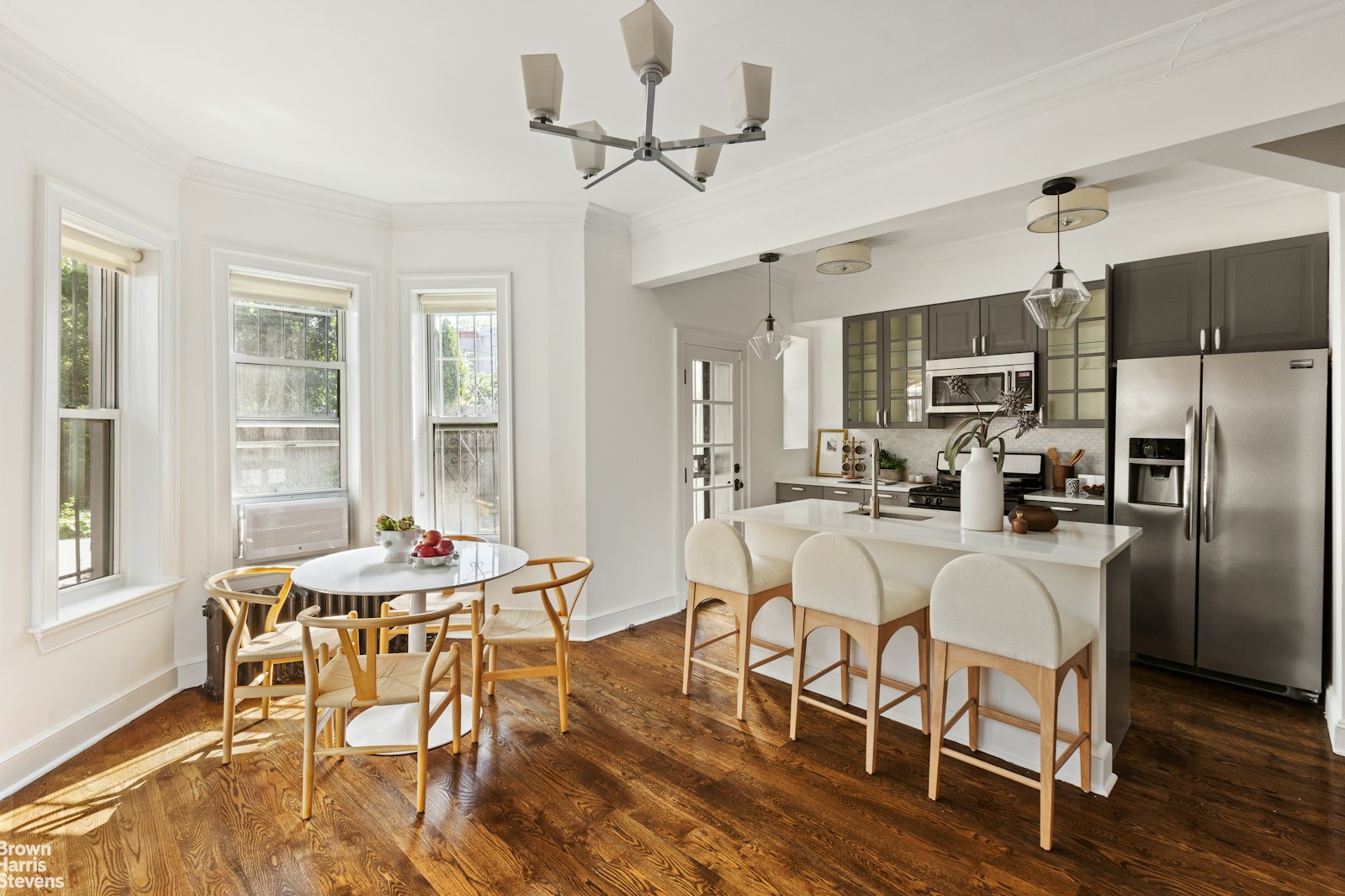 a view of a dining room with furniture a chandelier and wooden floor