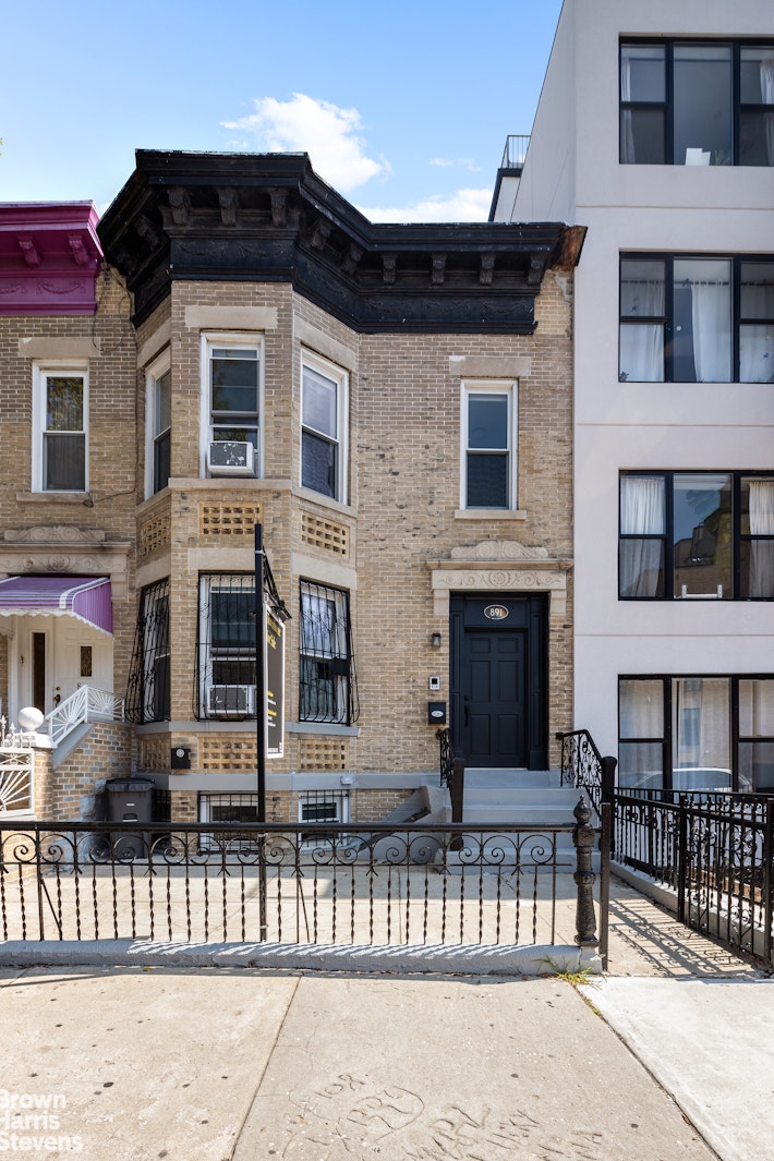891 Knickerbocker Avenue Brooklyn, NY 11207 - Photo 11 of 12 a view of a house with a small yard and wooden fence