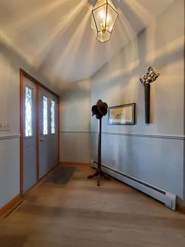 a view of a hallway with wooden floor and furniture