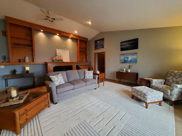 a living room with furniture a flat screen tv and kitchen view