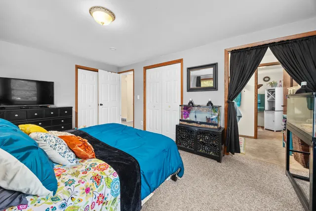 a bedroom with a bed and a tv on the dresser
