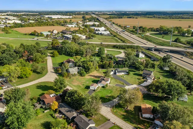an aerial view of residential house with outdoor space and trees all around